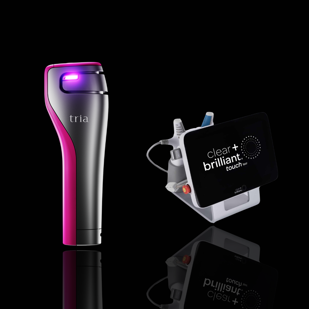A Tria laser hair removal device in metallic silver and hot pink stands next to a Clear + Brilliant Touch II treatment kit on a reflective black background.